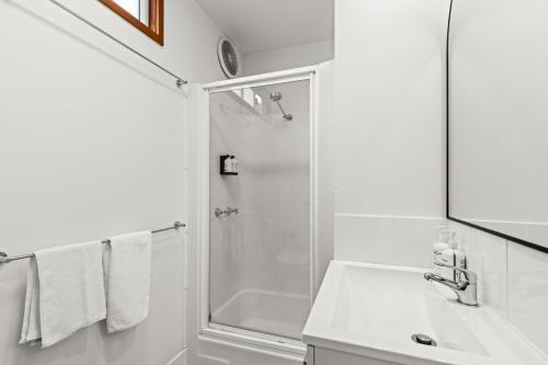 a white bathroom with a shower and a sink at Ingenia Holidays Torquay Australia in Torquay