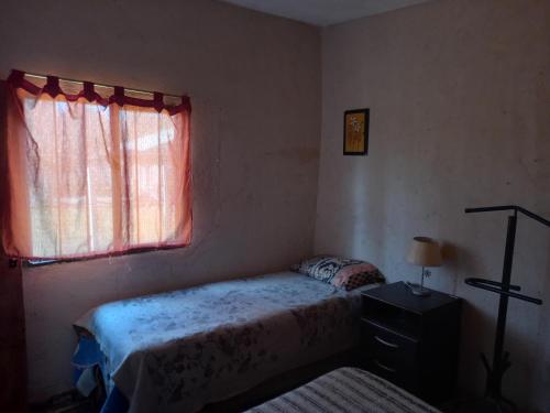 a small bedroom with a bed and a window at El PRADO in Alta Gracia