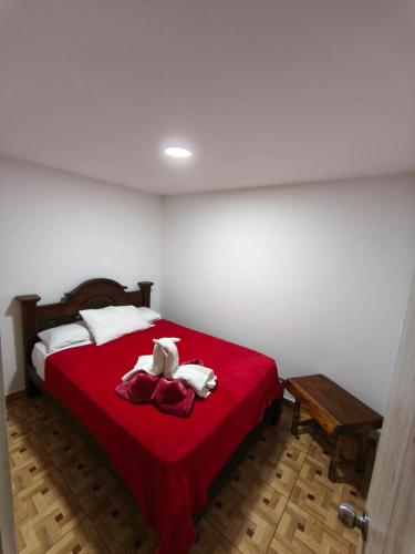 a bedroom with a red bed with towels on it at apartamento vacacional red 1 in Salento
