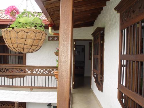 a balcony with a plant in a hanging basket at Casa Hotel Portón Campestre in Jardin