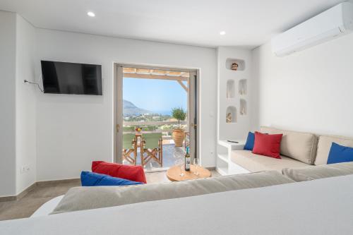 a living room with a couch and a large window at Epsilon Apartments in Kalymnos