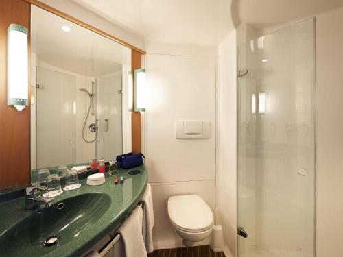 a bathroom with a sink and a toilet and a shower at ibis Hotel Berlin Spandau in Berlin