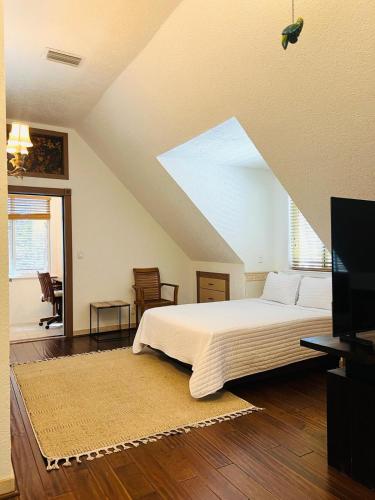 a bedroom with a large bed and a tv at Serenity Sands Cayman in Bodden Town