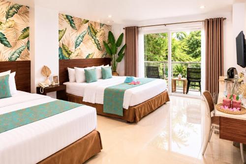 a hotel room with two beds and a window at Jony's Boutique Hotel in Boracay