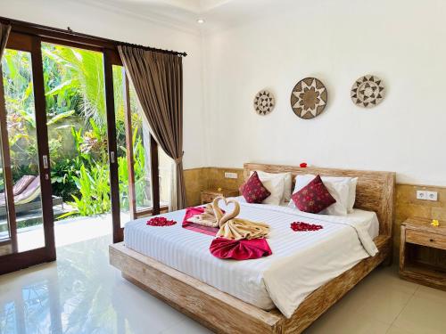 a bedroom with a bed with red flowers on it at Pulu Sari Suite Ubud in Ubud