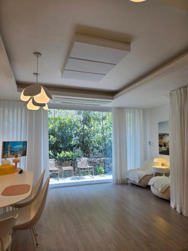 a large living room with a dining table and a room with at South Sagye Jeju in T'ogi-dong
