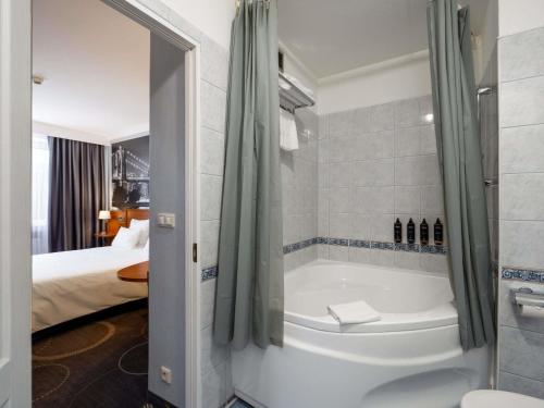 a bathroom with a bath tub in a room at Mercure Czestochowa Centrum in Częstochowa