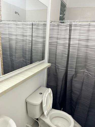 ein Badezimmer mit Toilette und Duschvorhang in der Unterkunft entresierras in Valledupar