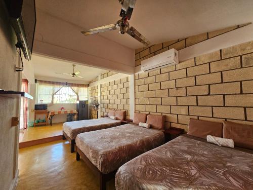 a room with three beds and a living room at Alojamiento El Dorado in Barrio Nuevo