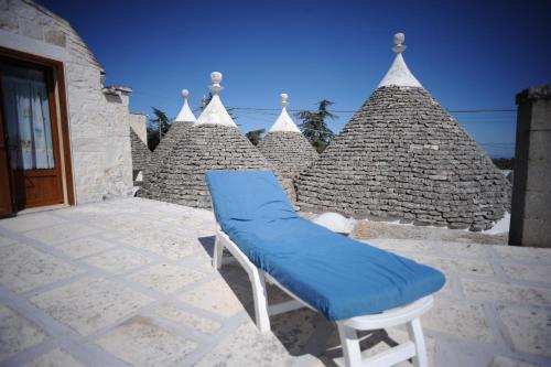 einem blauen Stuhl auf einer Terrasse mit einem Gebäude in der Unterkunft Casa Ciccone Cardone in Locorotondo
