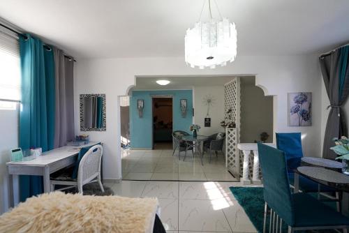 a dining room and living room with a table and chairs at Rowy's appartement in Willemstad