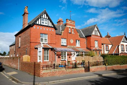 a large red brick house on the side of a street at Launceston Villa in Whitby