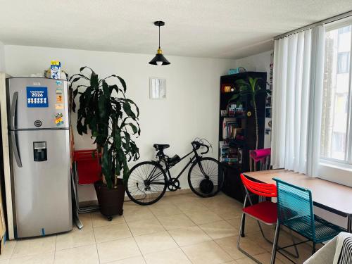 a kitchen with a refrigerator and a table and a bike at Lagom 406 Habitación en depa duplex in Mexico City