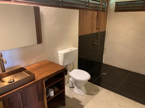 a bathroom with a toilet and a sink at Kooyu Villas in Port Vila