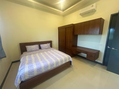 a bedroom with a bed and a desk in it at Private Pool Villa Huay Yai in Ban Bung