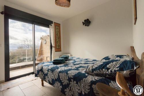 a bedroom with a bed and a view of a balcony at Gîte des petites pyrénées in Ausseing