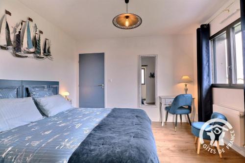 a bedroom with a bed and a table and a chair at Entre terre et mer in Cherrueix