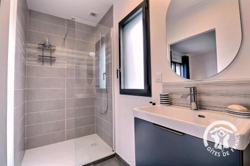 a white bathroom with a sink and a mirror at Entre terre et mer in Cherrueix