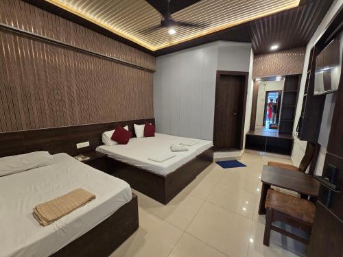 a hotel room with two beds and a chair at Hotel Vrindavan in Fatehpur Sīkri