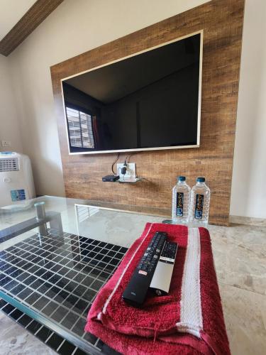a glass table with a remote control and two bottles of water at Castel Rock in Nashik