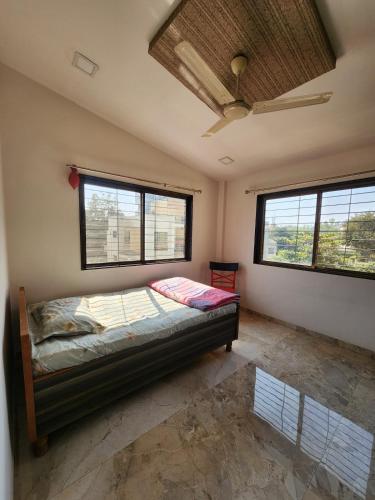 a bedroom with a bed in a room with windows at Castel Rock in Nashik