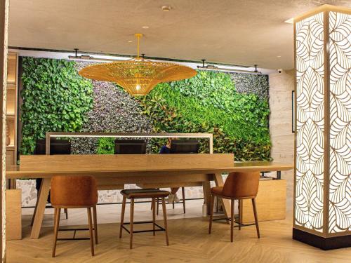 a dining room with a large green wall at ibis Dubai World Trade Centre in Dubai