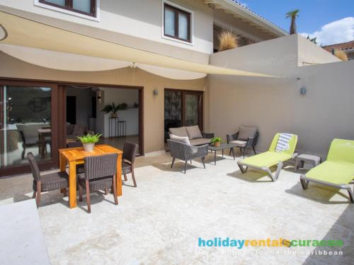 a patio with chairs and a table and an umbrella at Apartment 387 Blue Bay in Dorp Sint Michiel