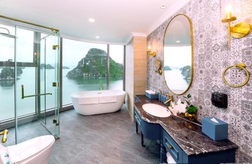 a bathroom with a tub and a sink and a mirror at Centara Hotel & Residences Van Don in Cái Rồng