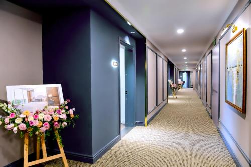 a corridor with blue walls and flowers in a hallway at Centara Hotel & Residences Van Don in Cái Rồng