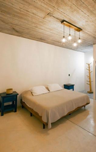 a bedroom with a large bed with two tables at Casa Gulal in Teotitlán del Valle