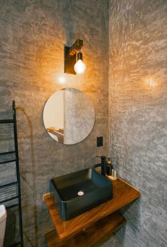a bathroom with a black sink and a mirror at Casa Gulal in Teotitlán del Valle
