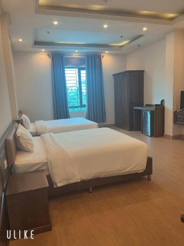 a hotel room with two beds and a television at Khách Sạn VizGoo in Bắc Ninh