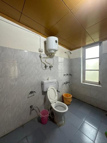 a bathroom with a toilet with a light on the ceiling at Thangkop House in Leh