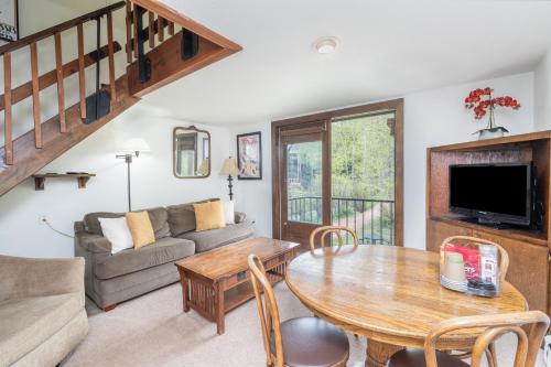 a living room with a table and a couch at Manitou Lodge 7 by Alpine Lodging Telluride in Telluride