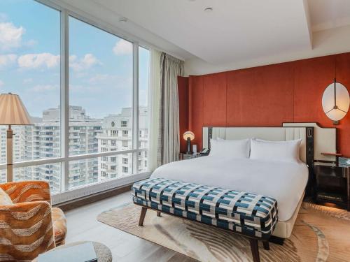ein Hotelzimmer mit einem Bett und einem großen Fenster in der Unterkunft Sofitel Montreal Golden Mile in Montreal