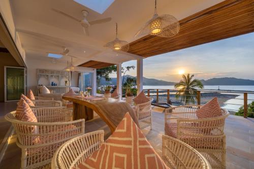 a restaurant with chairs and a table with a view of the ocean at Hortensia Luxury Beach Villa in Chaloklum
