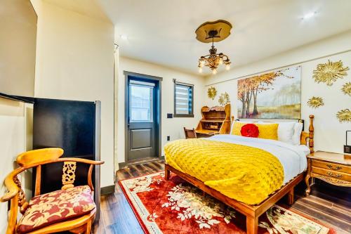 a bedroom with a yellow bed and a chair at Neocolonial Quarters in Vancouver