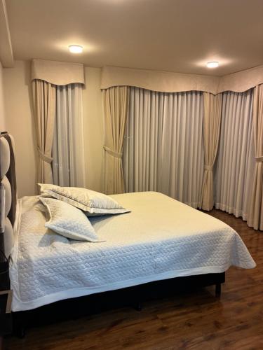 a bedroom with a bed with white sheets and pillows at House Mei in Oruro