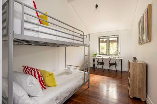 a bedroom with a bunk bed and a table at Lockn Heart Homestead in Quindalup