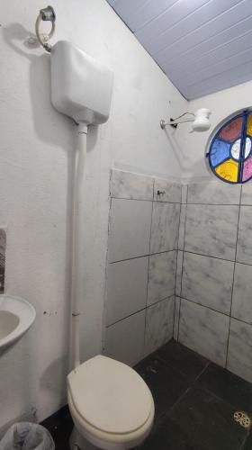 a bathroom with a toilet and a sink and a window at Apartamento no Camping Mairipora in Mairiporã