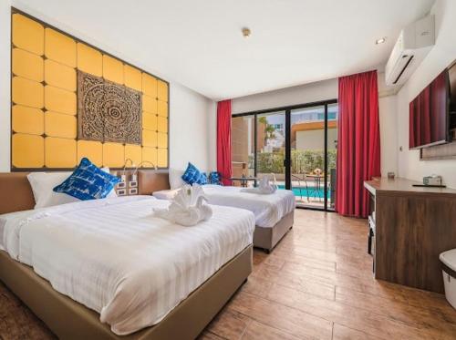ein Hotelzimmer mit zwei Betten und einem Badezimmer in der Unterkunft OK Phuket in Kata Beach