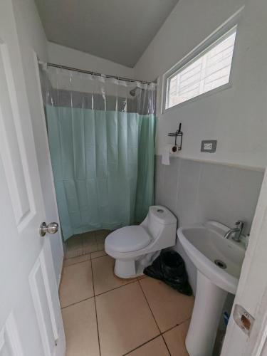a bathroom with a toilet and a sink at Hermosa casa cerca de todo in Sitio del Niño
