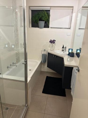a bathroom with a tub and a sink and a shower at Beautiful Brighton in Melbourne