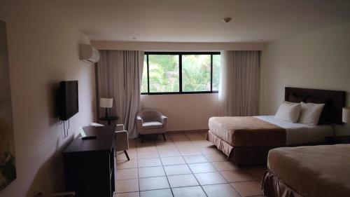 a hotel room with two beds and a television at Private family room in Coronado Luxury Club & Suites in Playa Coronado