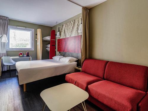 a hotel room with a bed and a couch at Ibis Madrid Fuenlabrada in Fuenlabrada