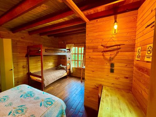 a bedroom with bunk beds in a wooden cabin at Cabañas ecológicas Xuetama in Villa de Leyva