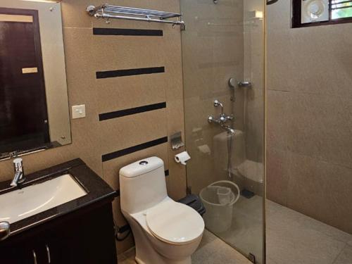 a bathroom with a toilet and a sink and a shower at Mannath Ayur Island Resort in Murinjupuzha
