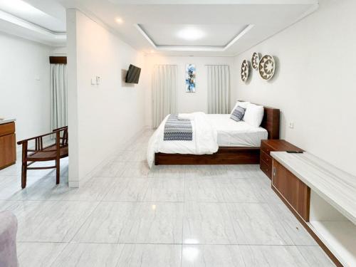 a white bedroom with a bed and a table at The Lavana Pondok JegegBagus near Pandawa Beach in Ungasan