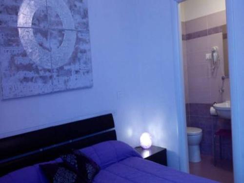 a bedroom with a purple bed and a bathroom at Magic Stefy's Rooms in Rome
