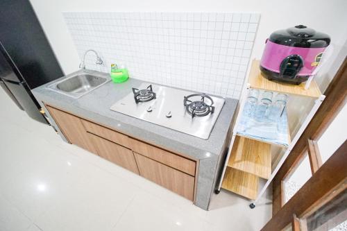 a small kitchen with a sink and a stove at Awana Town House 40 in Timuran